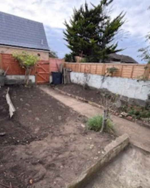 A garden stripped back to tidy soil beds and a clear path